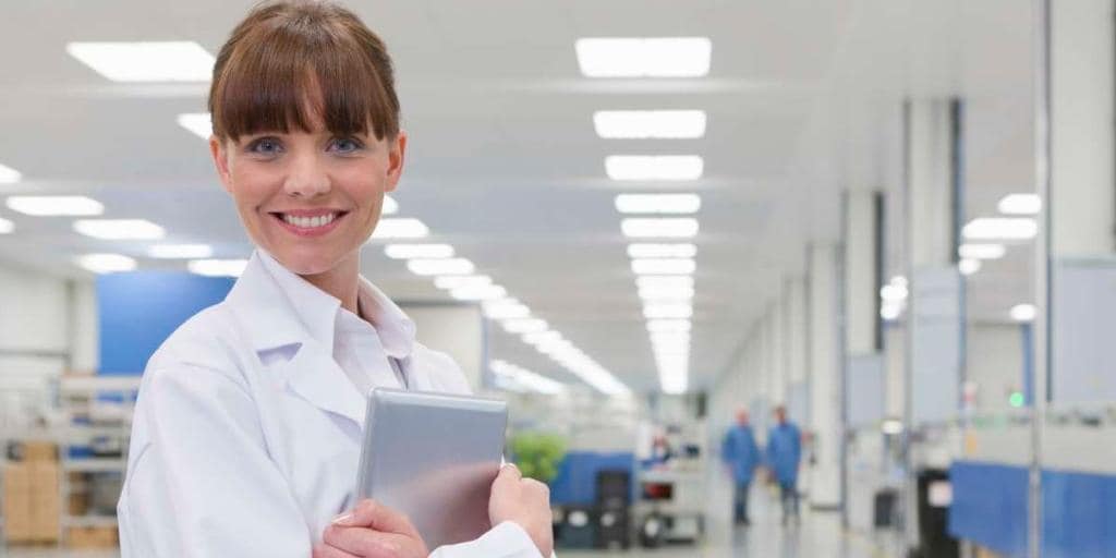Smiling scientist in high-tech manufacturing plant