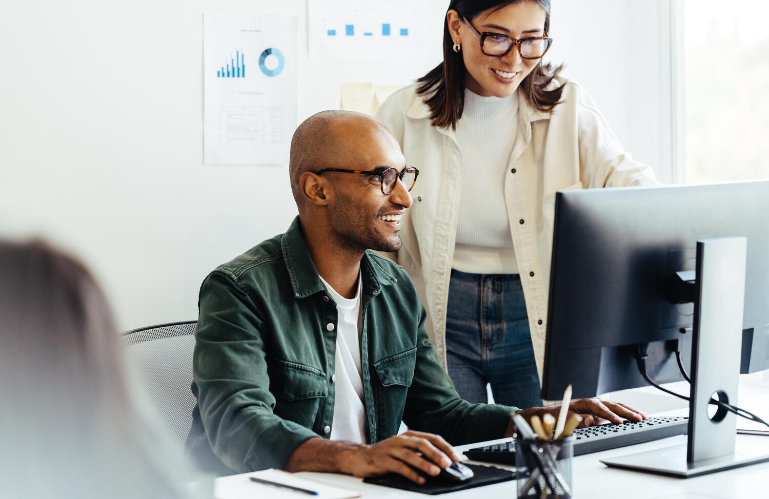 Web developers using a computer together in an office